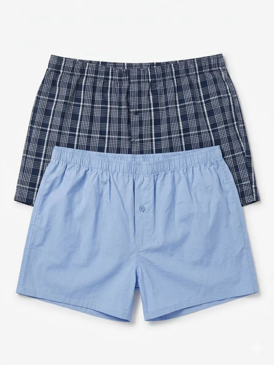 Two pairs of men's boxer shorts, one plaid and one solid blue