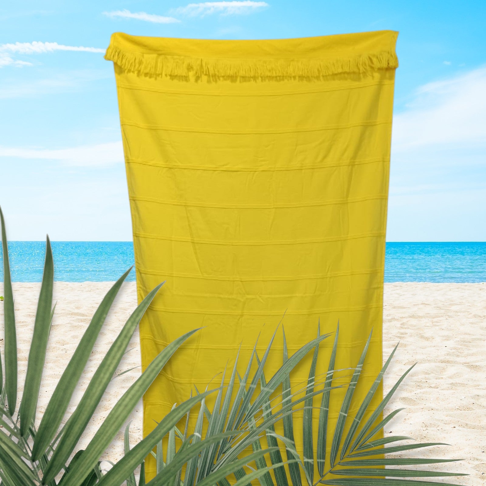 Yellow towel on a beach with ocean and sky in the background